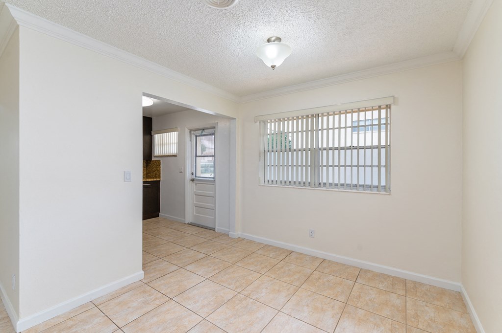 an empty kitchen and living room with tile flooring and a window