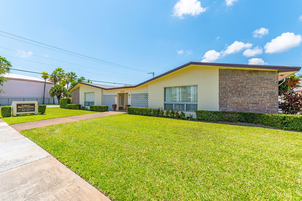 a house with a lawn and a sidewalk in front of it