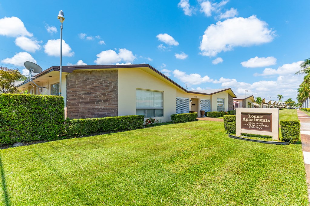 a house with a lawn and a sign in front of it