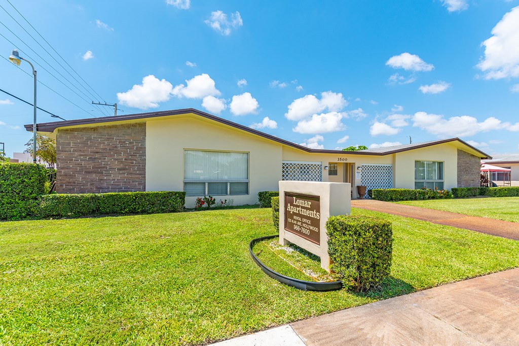 a house with a lawn and a sign in front of it