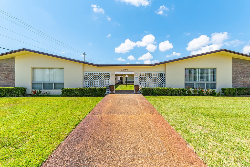 a house with a walkway and grass in front of it