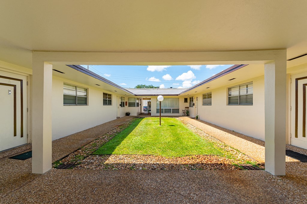 a view of a courtyard in a building with grass