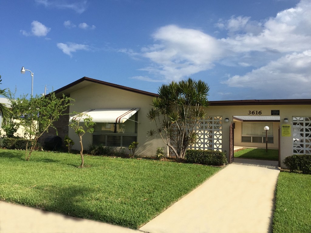 a house with a yard and a sidewalk in front of it