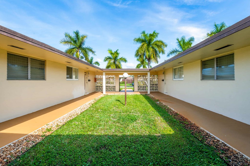 a yard in front of a house with palm trees