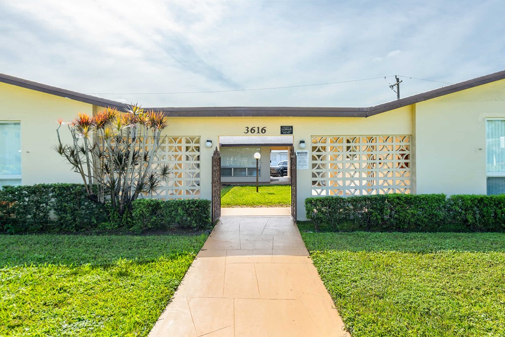 a house with a yard and a sidewalk in front of it