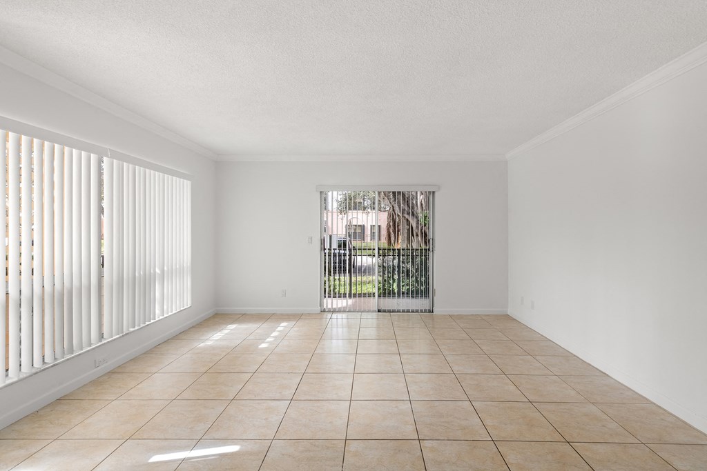 an empty living room with a sliding glass door to a patio