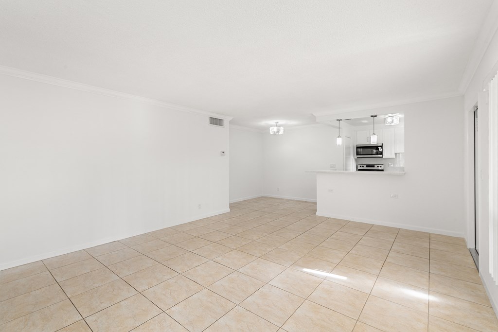 an empty living room with tiled floor and white walls