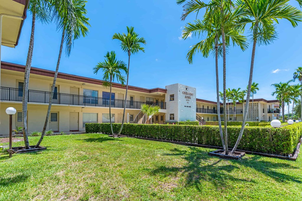 a building with palm trees and grass in front of it