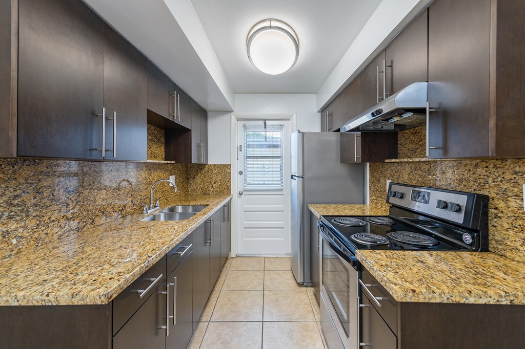 a kitchen with granite counter tops and stainless steel appliances