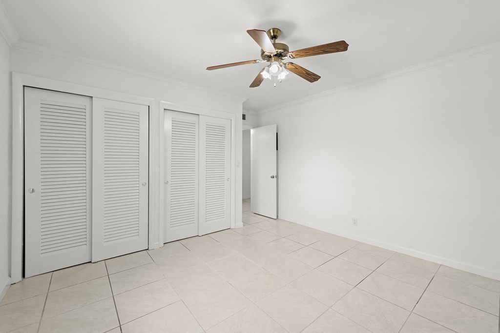 a large room with a ceiling fan and a tiled floor