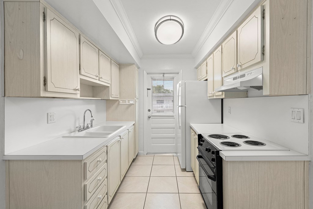 a kitchen with white cabinets and a stove and a sink