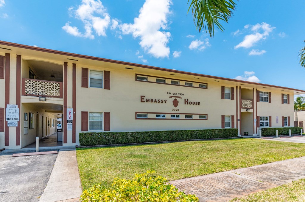 a building with a lawn and a sign that reads embassy house