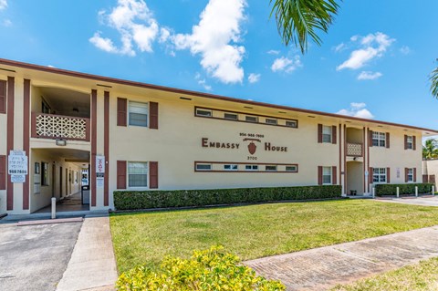 a building with a lawn and a sign that reads embassy house