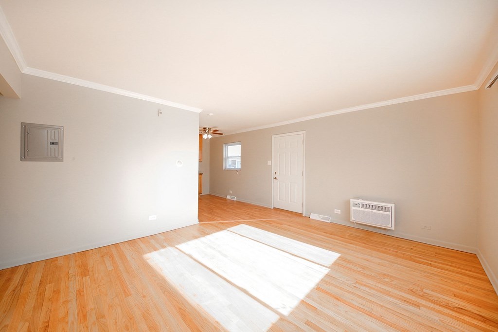 the living room and dining room of a house with wood floors and a white wall