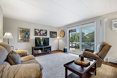 a living room with couches and a coffee table and a sliding glass door