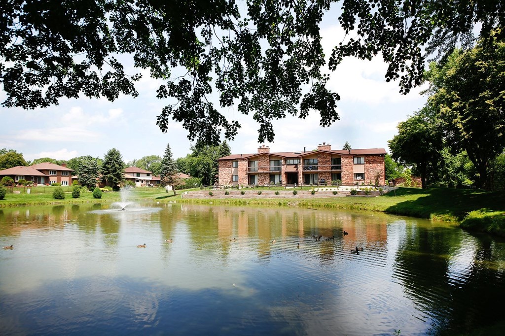 a lake with a fountain in front of a large building