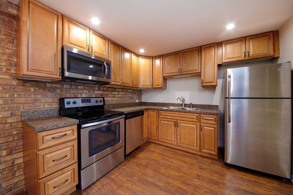 a kitchen with wooden cabinets and stainless steel appliances