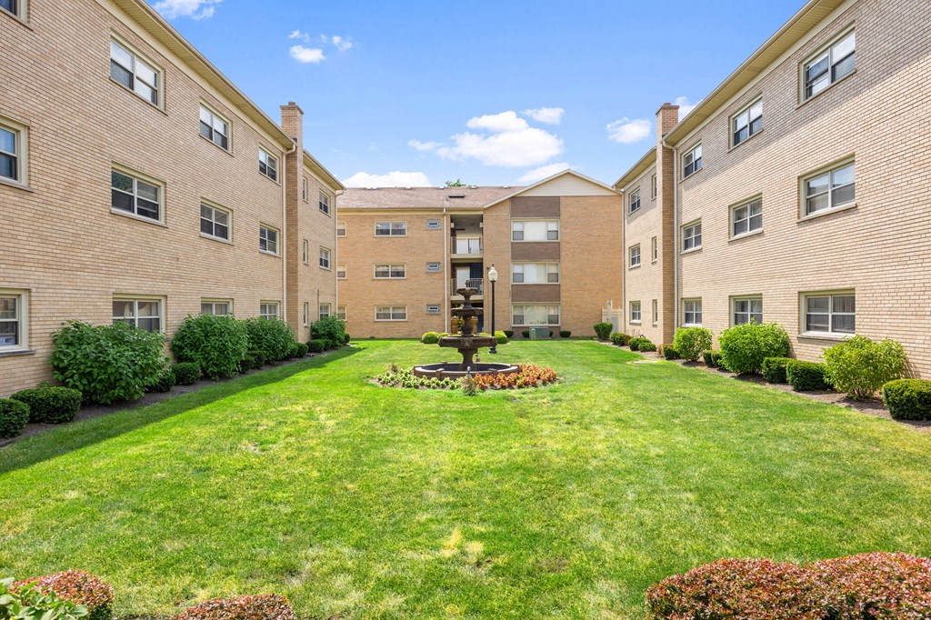 a courtyard with a fountain in the middle of an apartment building