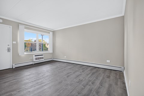 A room with a large window and a wooden floor.