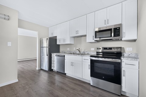 A kitchen with white cabinets and stainless steel appliances.