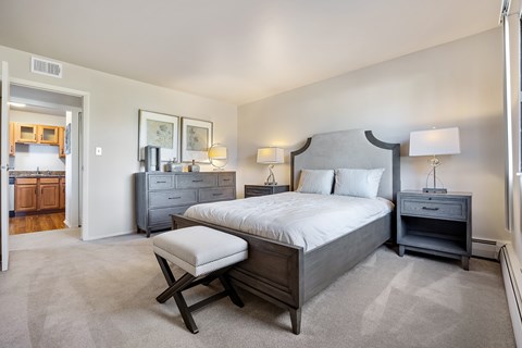 A bedroom with a large bed and a chair.