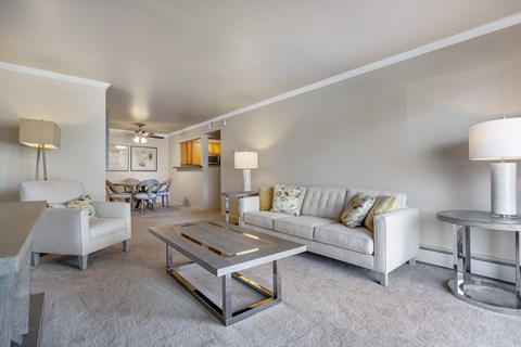 A living room with a white couch and a coffee table.