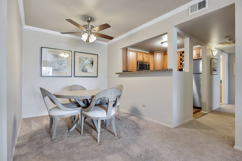 A dining room with a table and chairs.