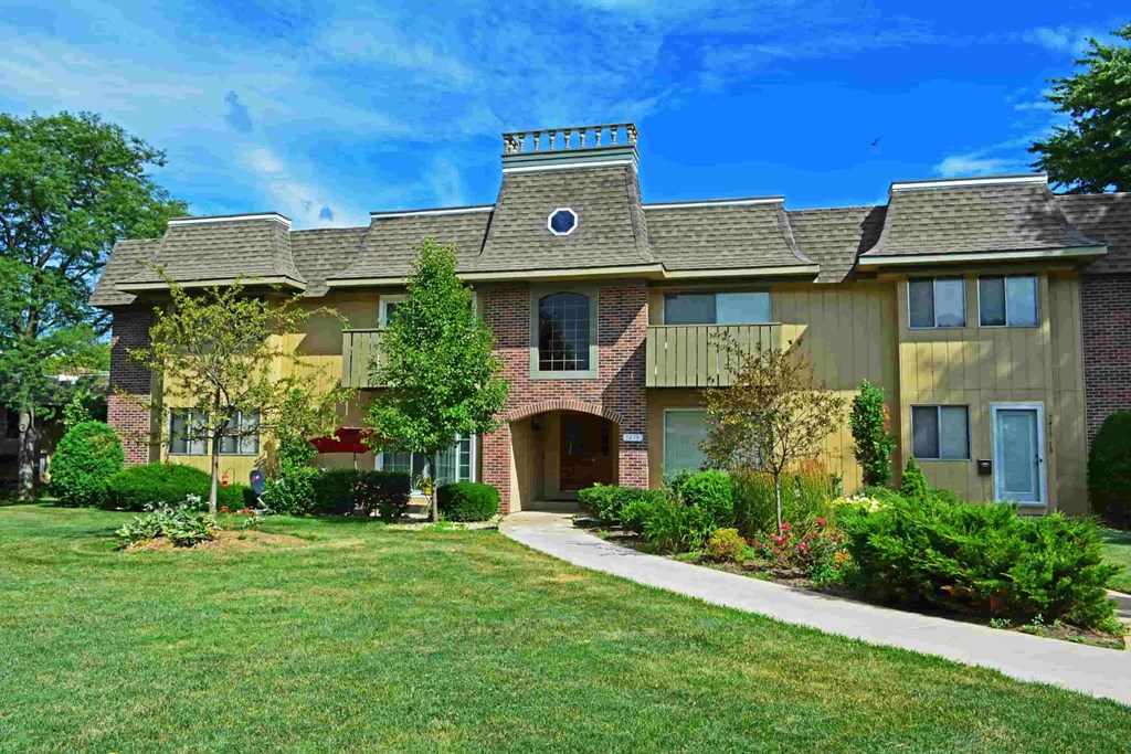 A large house with a well-maintained lawn in front.