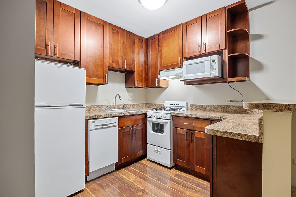 A kitchen with wooden cabinets and a white refrigerator.