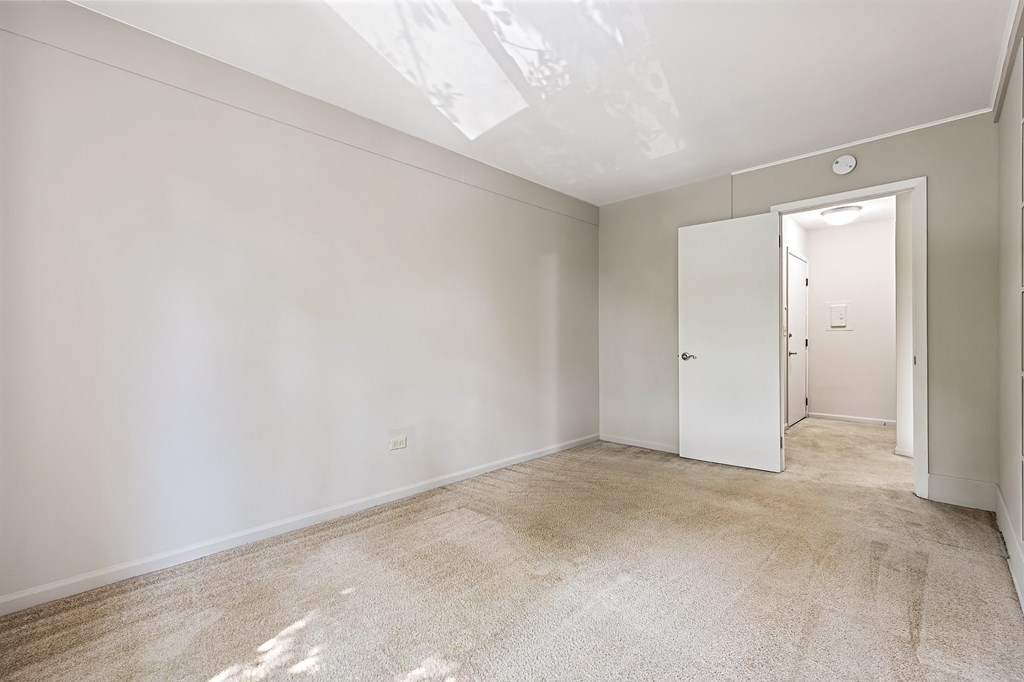 A room with a carpeted floor and a white door.