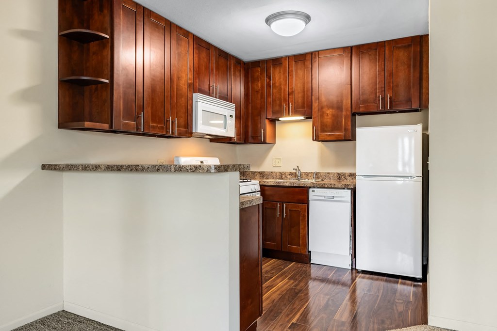 A kitchen with wooden cabinets and a white refrigerator.