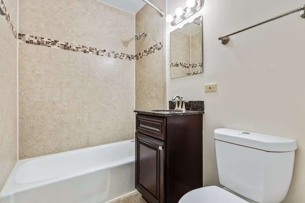 A white toilet sits next to a bathtub in a bathroom.