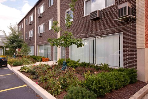 A brick building with a parking lot in front.