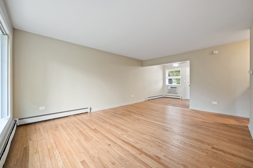the living room and dining room of an empty house with wood floors