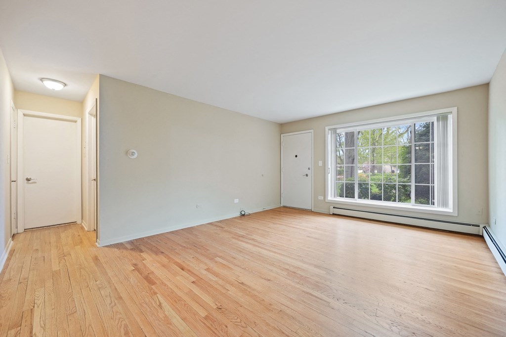 a living room with wood floors and a large window