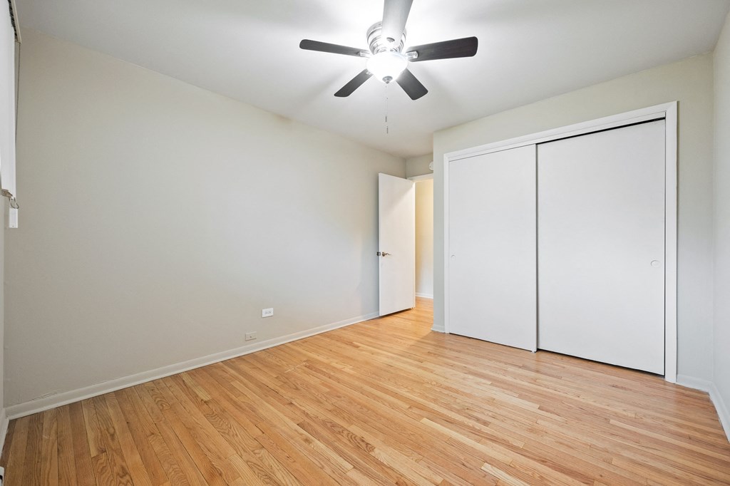 an empty living room with white walls and a ceiling fan
