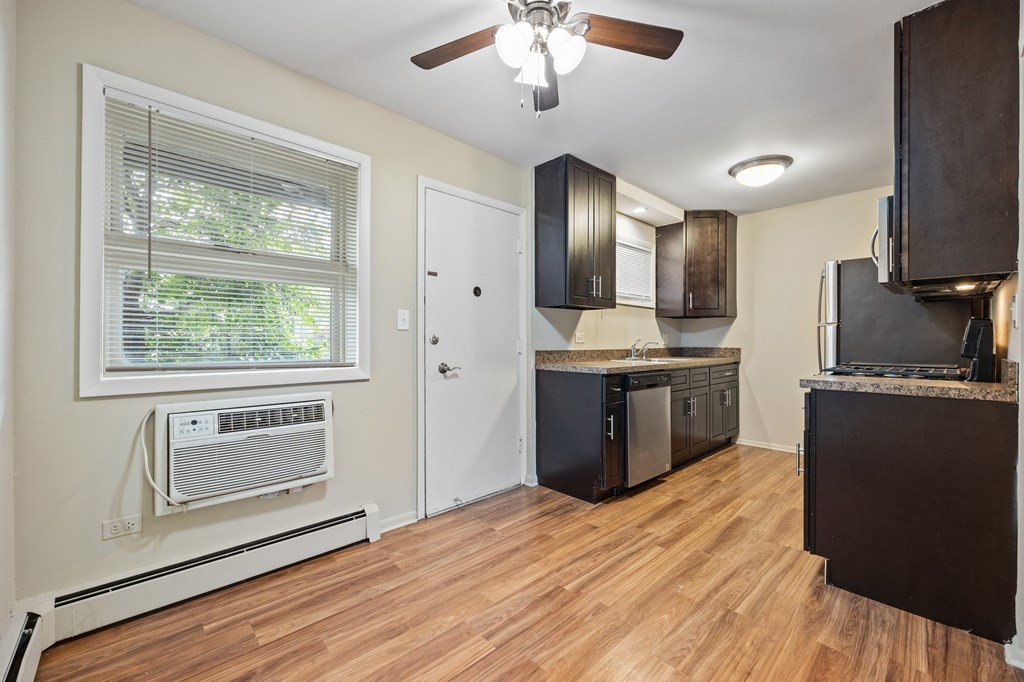an empty kitchen with wood flooring and a window