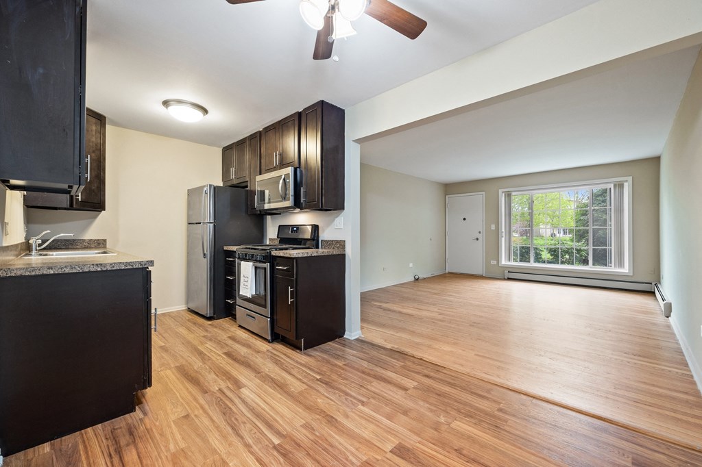 the view of a kitchen and living room with wood floors and a large window