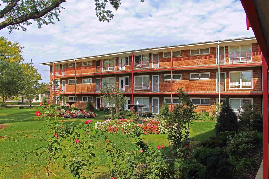 a view of an apartment building with a garden in front of it