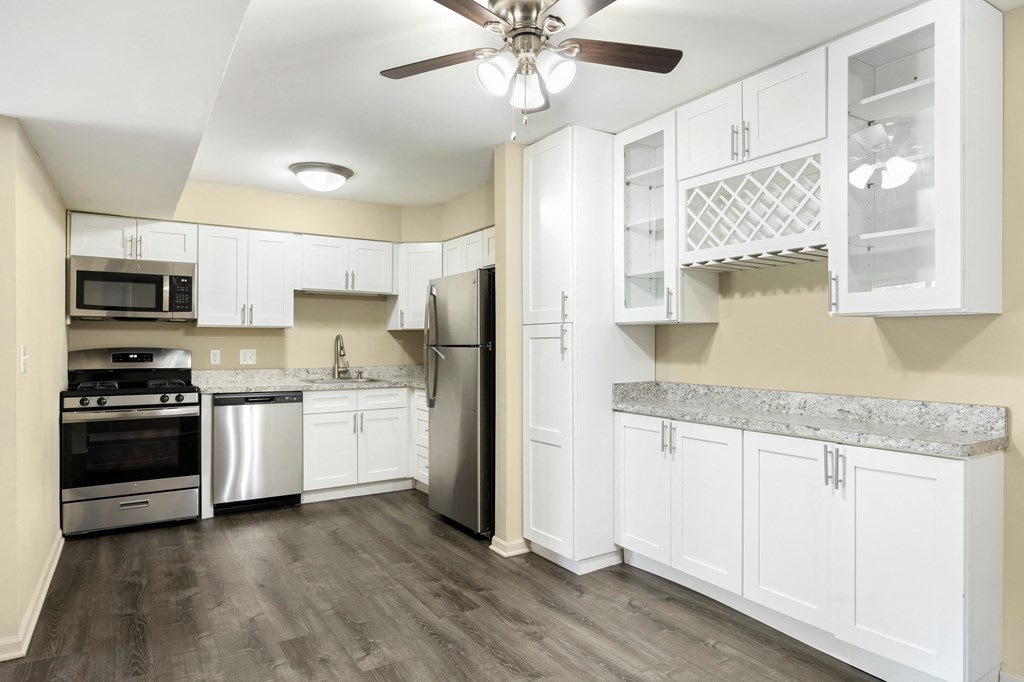 a renovated kitchen with white cabinets and stainless steel appliances