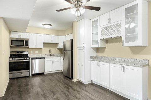a renovated kitchen with white cabinets and stainless steel appliances