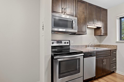 the kitchen of a home with stainless steel appliances and wooden cabinets