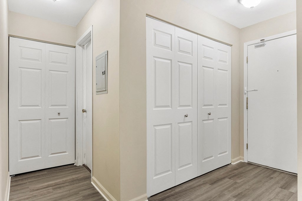 a bedroom with white closets and doors and wood flooring