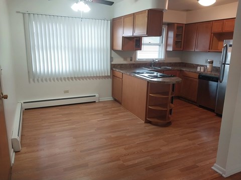 A kitchen with wooden floors and a black stove top.
