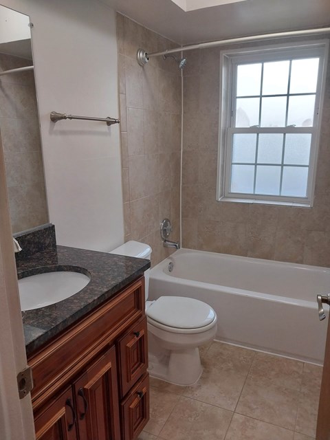 A bathroom with a toilet, sink, and bathtub.