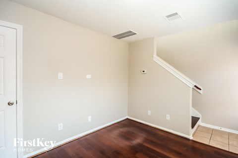 a empty room with wood flooring and a white wall