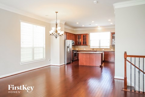 a kitchen and living room with wood floors and white walls