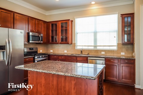 an updated kitchen with cherry wood cabinets and granite counter tops