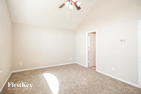 a bedroom with a ceiling fan and a carpeted floor