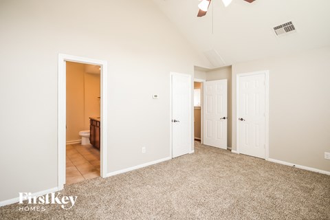 a master bedroom with two closets and a door to a bathroom